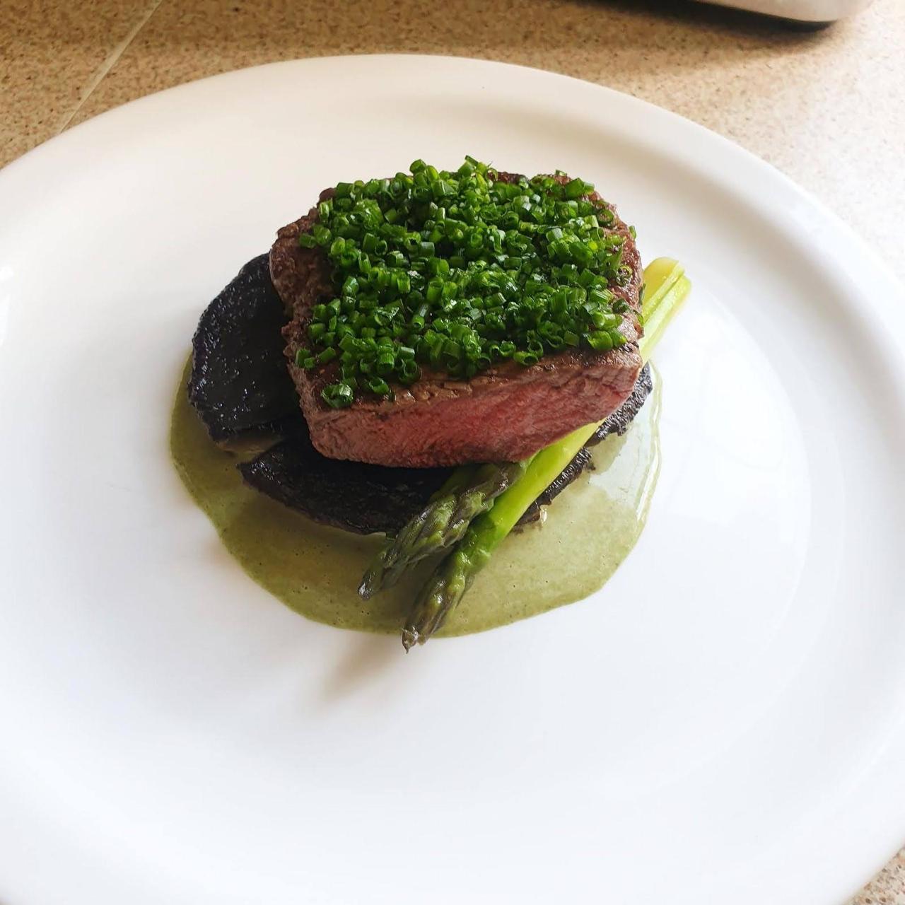 Beef tenderloin with chives over charred asparagus and portobello