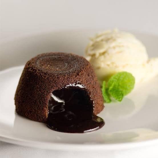 Warm molten chocolate cake with flowing center and vanilla gelato