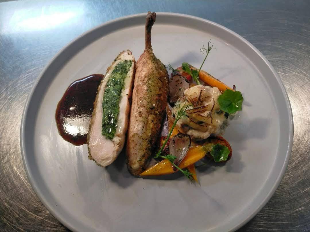 Pan-roasted stuffed chicken supreme with herb filling and glazed carrots