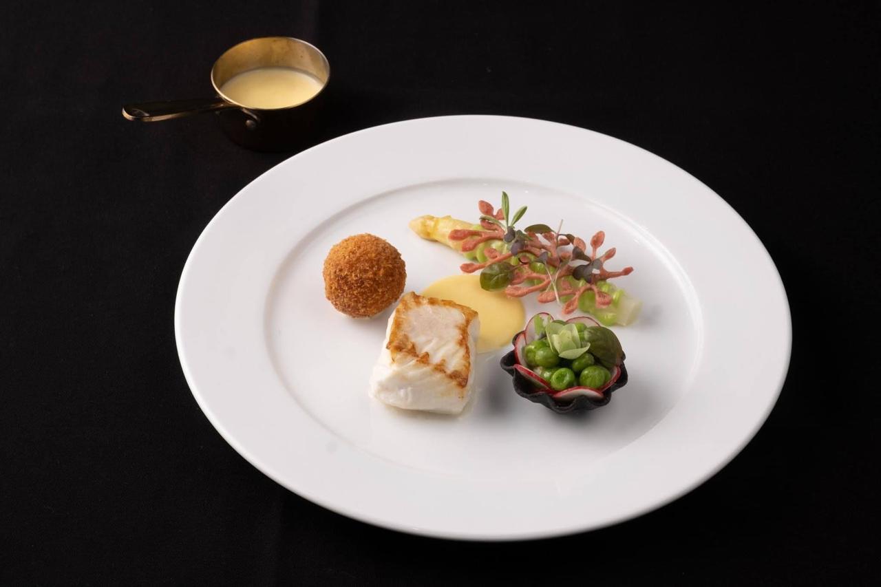 Crisp white fish fillet with golden croquette and pea tartlet